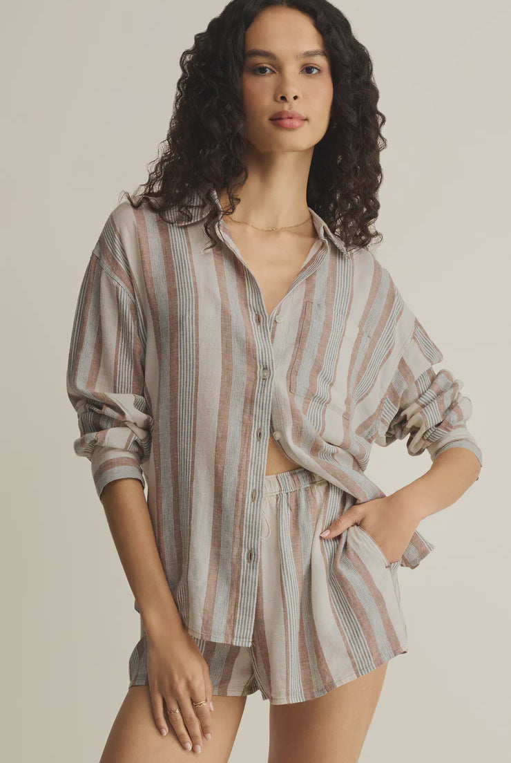 Woman wearing a striped shirt and shorts set on a beige background