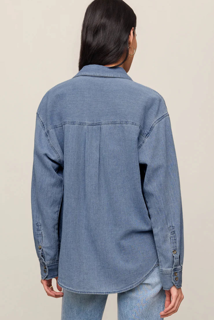 Relaxed-fit indigo cotton twill button-up shirt with a collared neckline, long sleeves, button-front closure, and a single chest pocket. Made from 100% cotton with a soft, drapey feel.