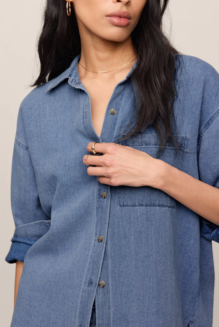 Relaxed-fit indigo cotton twill button-up shirt with a collared neckline, long sleeves, button-front closure, and a single chest pocket. Made from 100% cotton with a soft, drapey feel.
