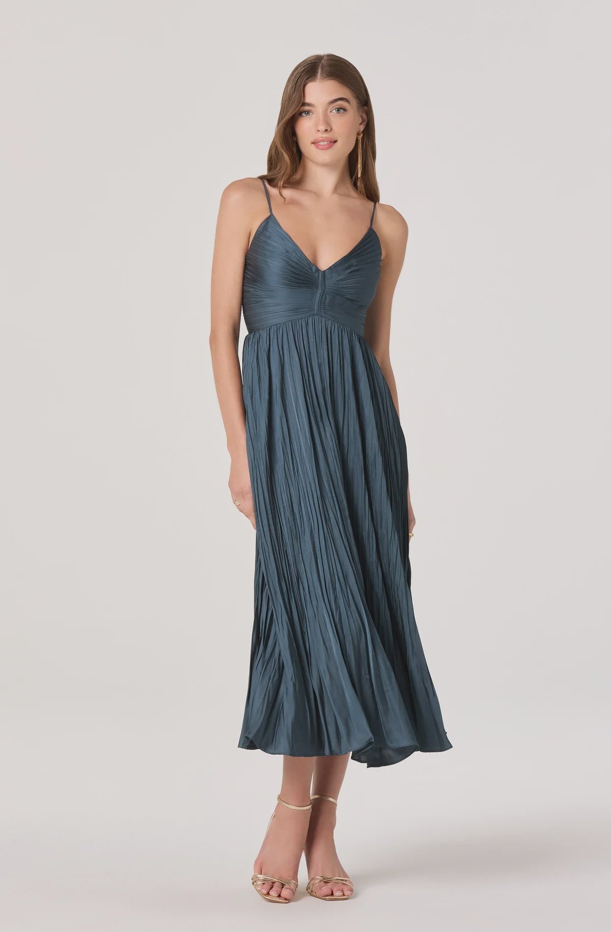 Woman wearing a teal dress on a white background