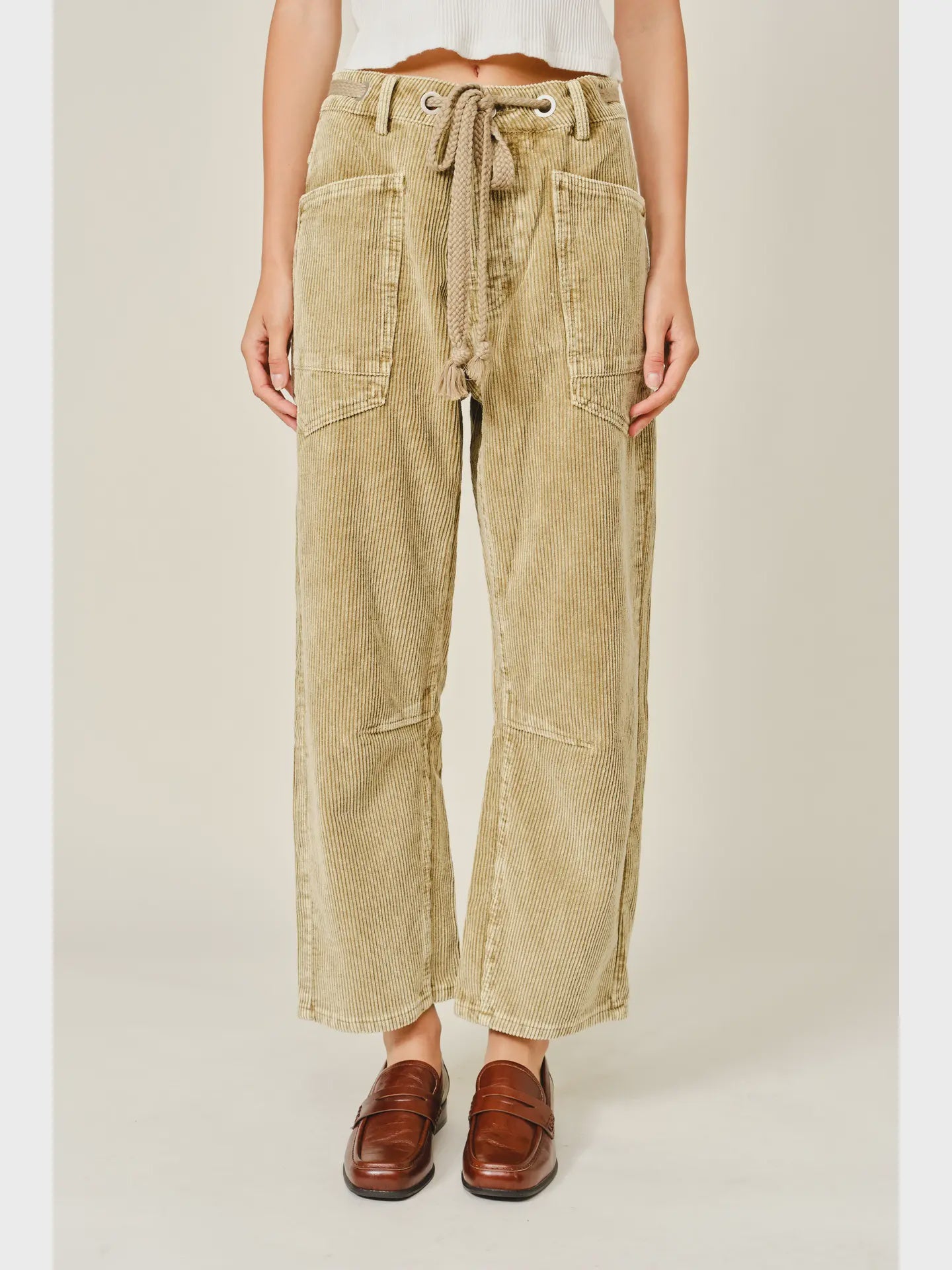 Women’s camel corduroy trousers featuring a subtle barrel fit, utility patch pockets, belt loops, and a rope tie waist.