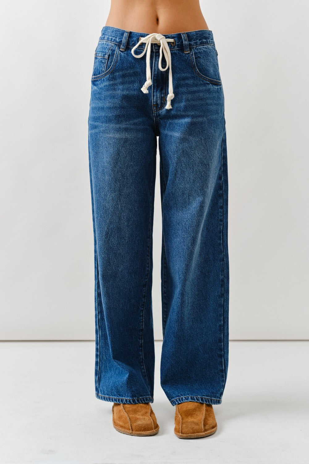Blue jeans with a drawstring waist on a white background