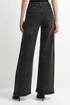 Washed black denim jeans with a flattering leg and rhinestone detailing, adding a subtle western-inspired touch.