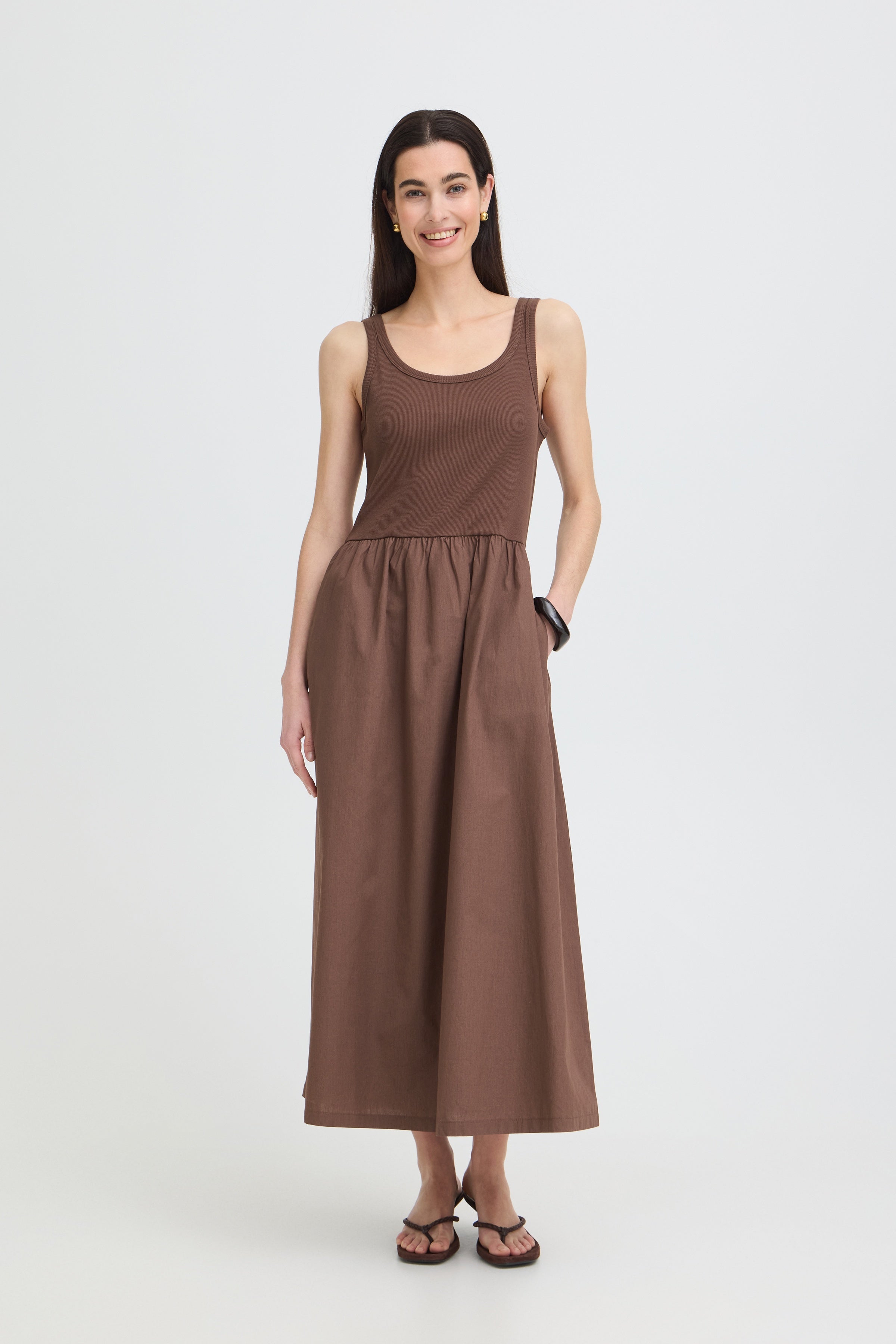 Woman wearing a brown sleeveless dress 