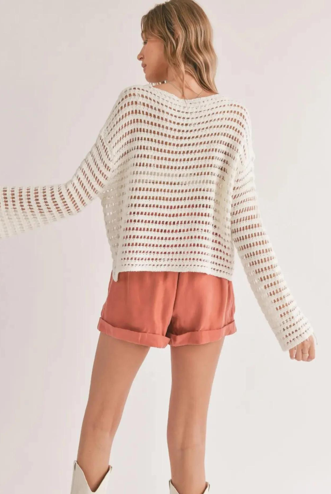 Sadie & Sage Carlita Open Knit Sweater - White. This open knit sweater is perfect for chilly days or evenings. The lightweight material keeps you comfortably warm, while the unique open knit pattern adds a touch of sophistication. The long sleeves offer both style and coverage, and the loose fit allows for unrestricted movement. A versatile piece that can be worn solo or layered, this sweater is a must-have for any fashion-forward wardrobe.