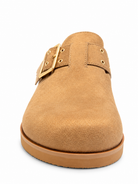 Chinese Laundry Cove Suede Clogs in Natural, featuring a natural faux-suede upper, gold-tone buckle with a rounded closed toe, open-back slip-on design, and contrasting sole.
