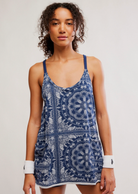 Woman wearing a blue patterned dress against a plain background