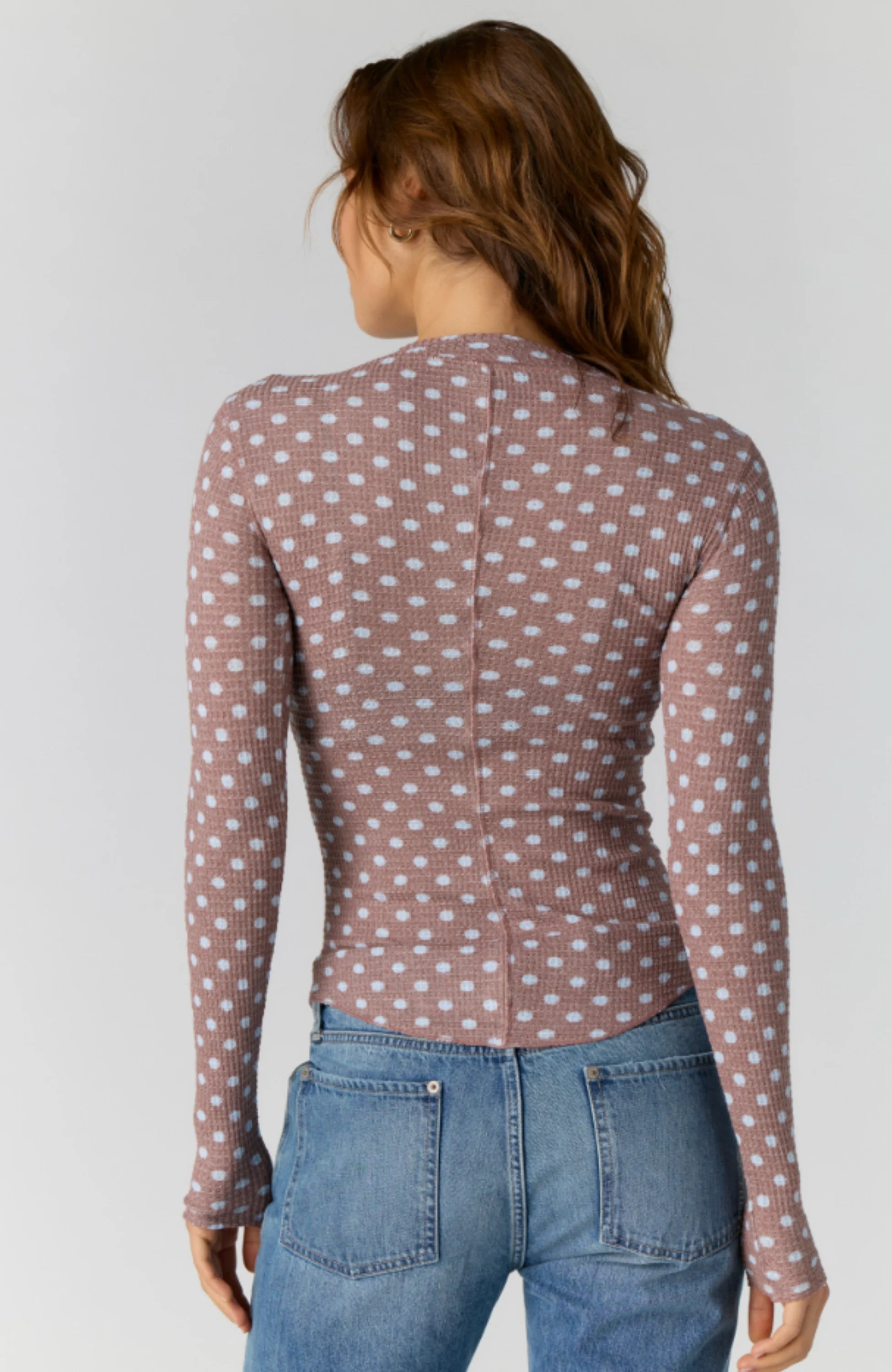 Fitted waffle-knit cardigan in a chocolate polka dot print with a crew neckline, long fitted sleeves, and snap-button front closure.