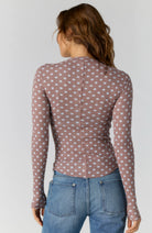 Fitted waffle-knit cardigan in a chocolate polka dot print with a crew neckline, long fitted sleeves, and snap-button front closure.