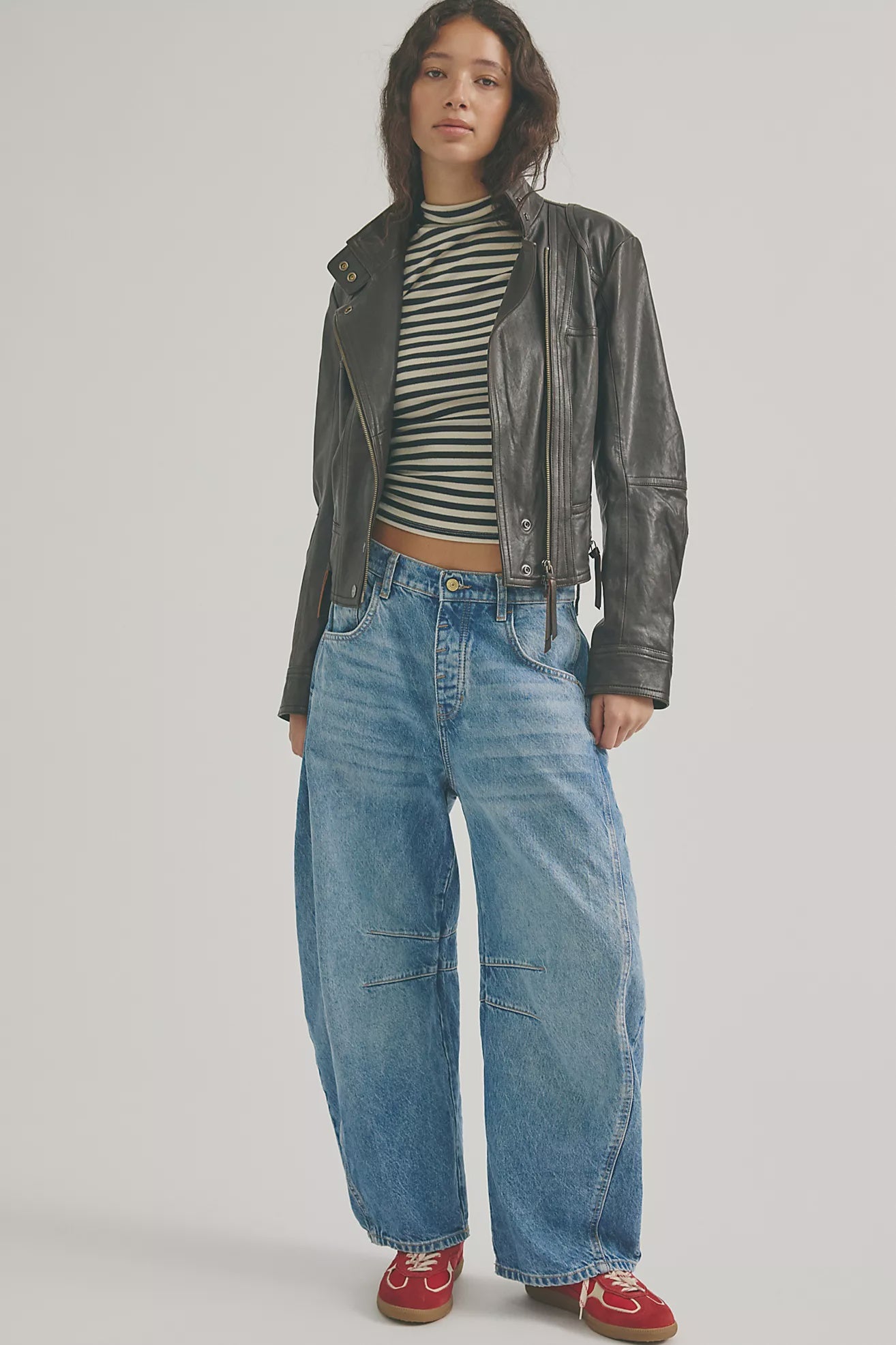 woman wearing ankle length barrel jeans in a mid wash and mid rise