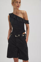 Woman wearing a black one-shoulder top 