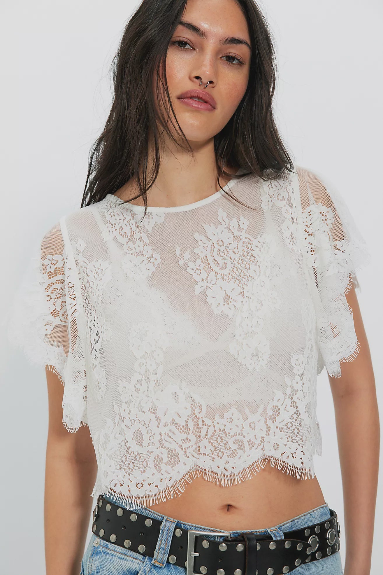 Woman wearing a white lace top with sheer sleeves