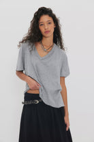 Woman wearing a gray oversized v-neck t-shirt 
