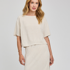 Woman wearing a beige outfit on a white background