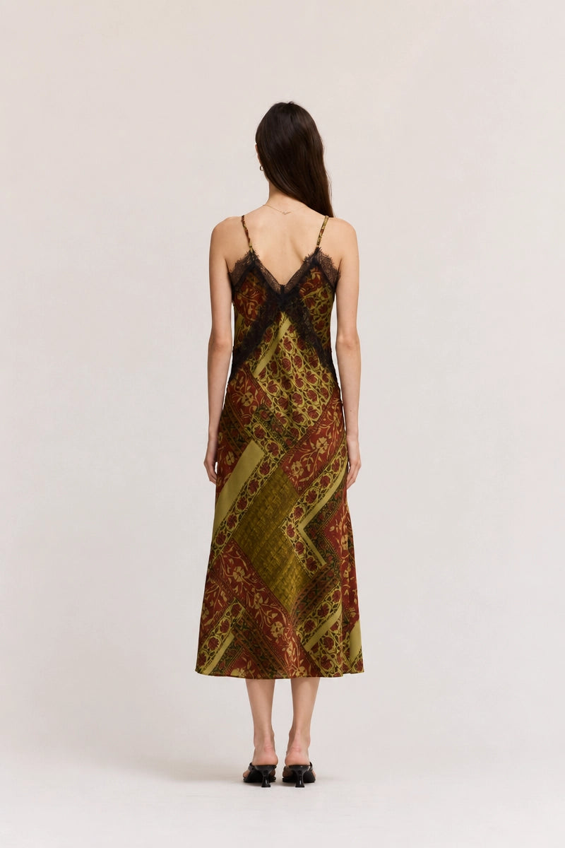 Gia midi satin slip dress featuring an abstract geometric print in olive green, cream, and red-brown tones, with lace trim, V-neckline, and adjustable straps.