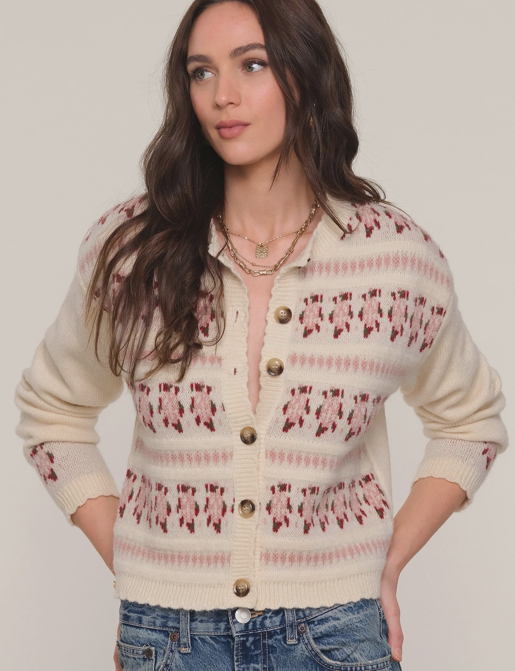 Woman wearing a patterned cardigan with a neutral background