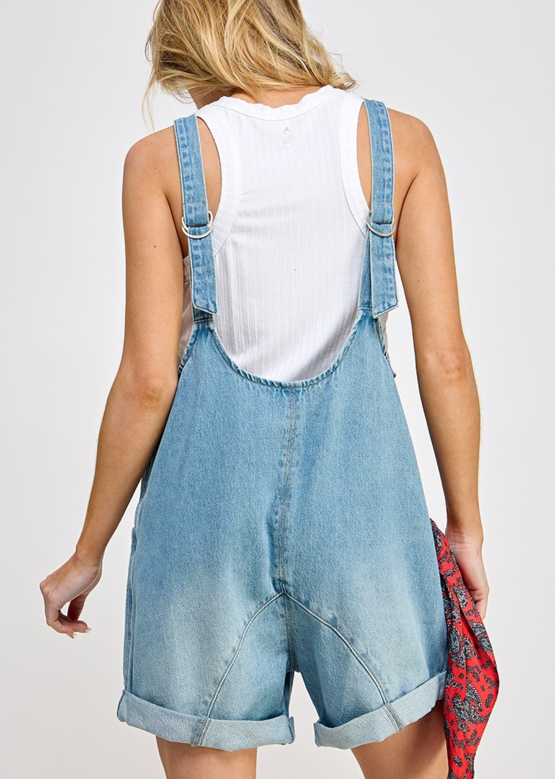High Roller romper - Denim fabrication, rigid feel, low scoop neckline, seam detail throughout, oversized patch pockets, drop-crotch harem-style legs, low back with adjustable shoulder straps.