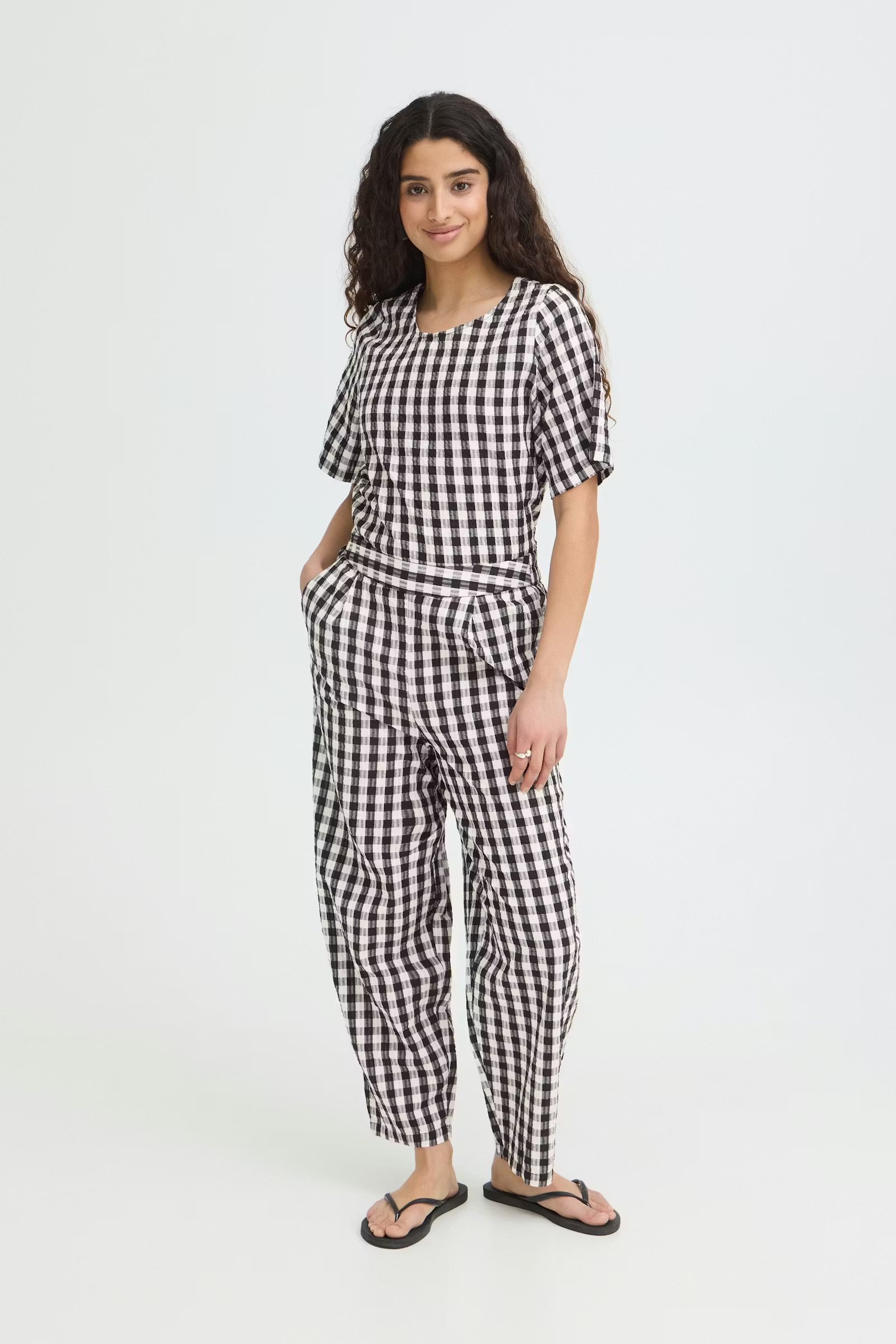 Woman wearing black and white gingham barrel trousers 
