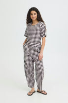 Woman wearing black and white gingham barrel trousers 