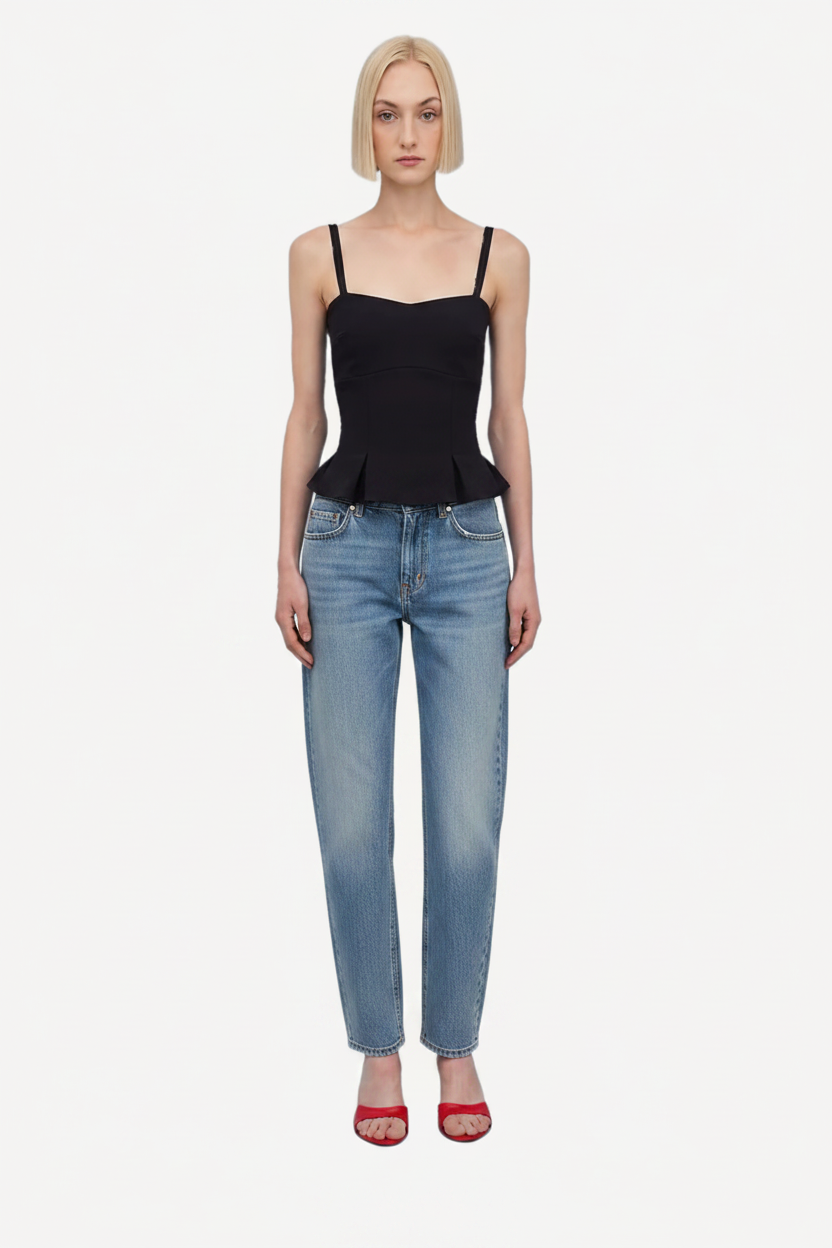 Woman wearing a black peplum top and capri pants on a white background