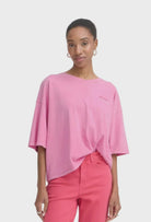 Woman wearing a pink top and pants on a white background