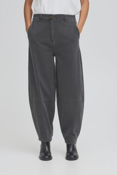 Person wearing dark gray pants on a white background