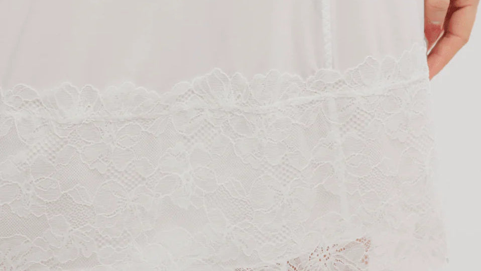 White lace-trimmed skirt worn by a person on a plain background