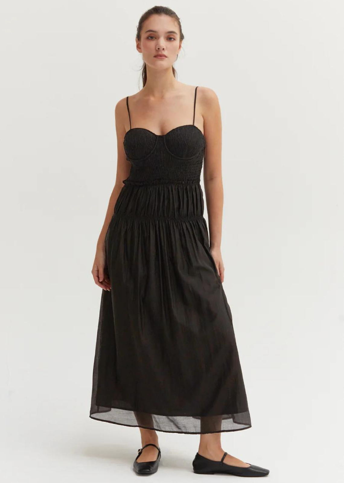 Lucy Tencel Blend Midi Dress- Black.Made with airy and semi sheer Tencel-blend, the Lucy Tencel Blend Midi Dress features smocked bustier with bra cup, adjustable spaghetti straps, side invisible zipper closure, and elasticized ruffle detail at waistline.