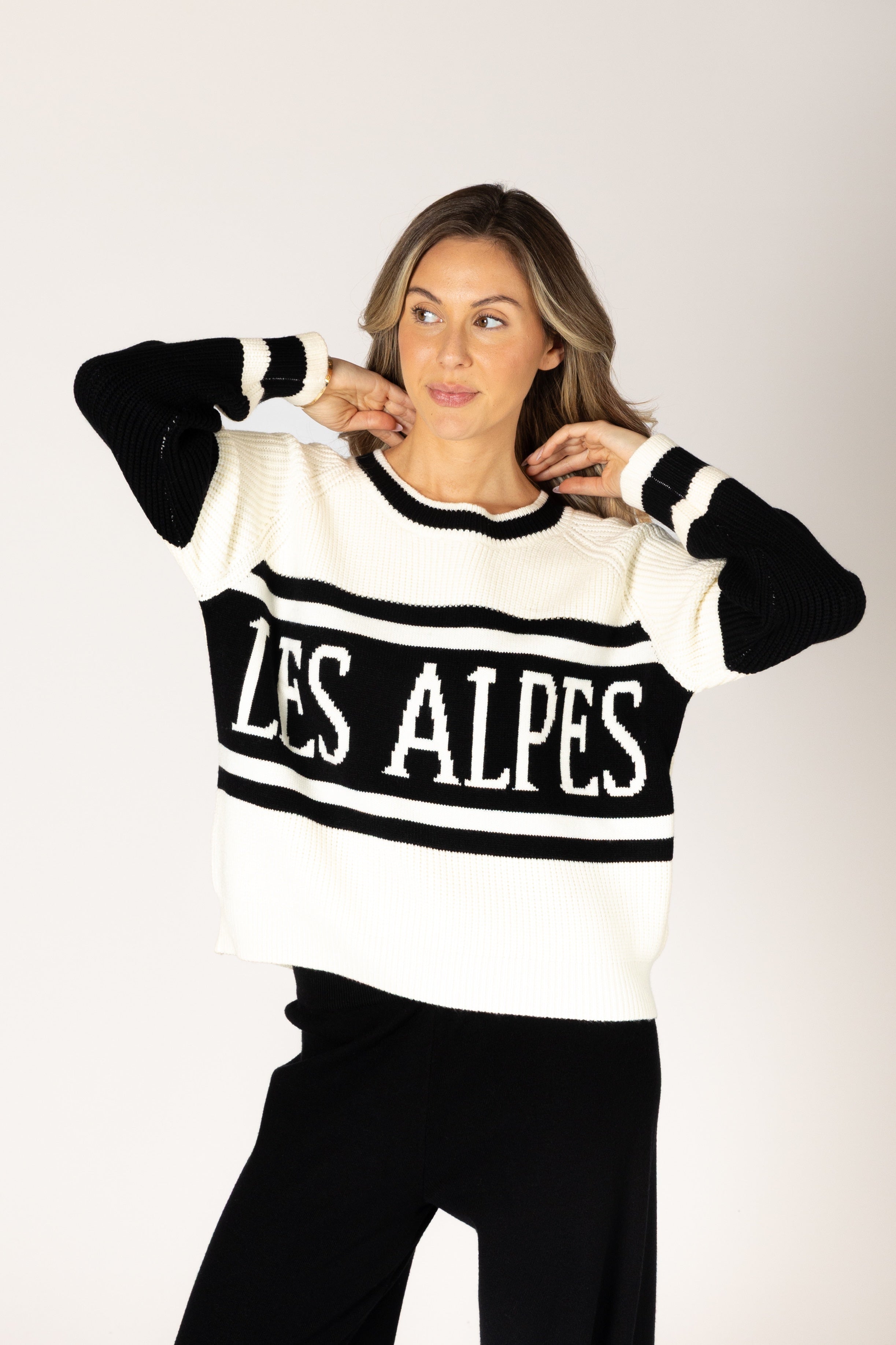 Black-and-white crewneck sweater featuring bold “LES ALPES” lettering across the front and a relaxed fit.
