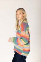 Multicolor striped fuzzy knit sweater featuring a relaxed fit, classic crew neckline, long sleeves, and ribbed cuffs and hem.

