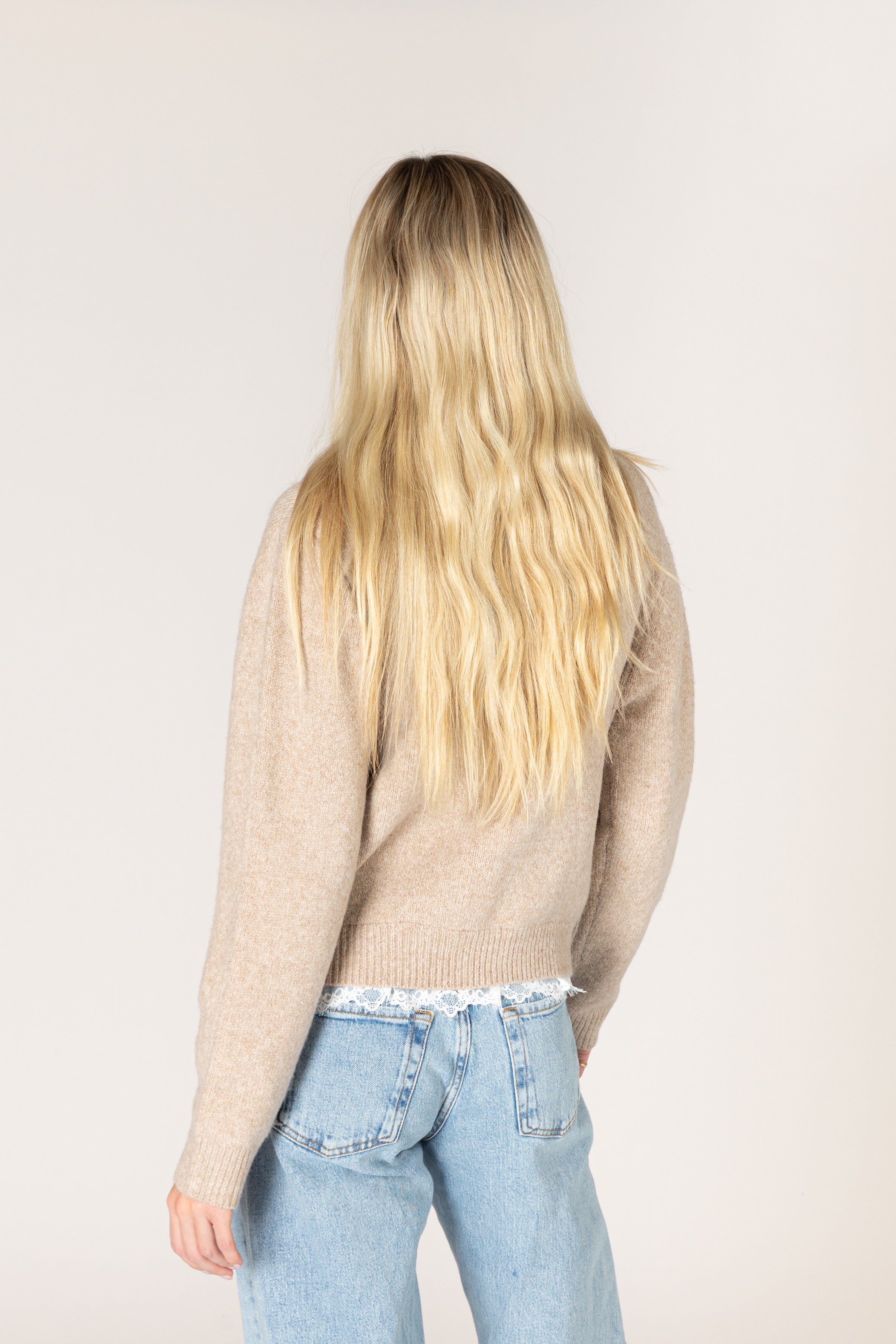 Lightweight knit cardigan featuring a classic crew neckline, button-front closure, long sleeves, and delicate lace trim along the hem and cuffs.
