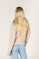Lightweight knit cardigan featuring a classic crew neckline, button-front closure, long sleeves, and delicate lace trim along the hem and cuffs.
