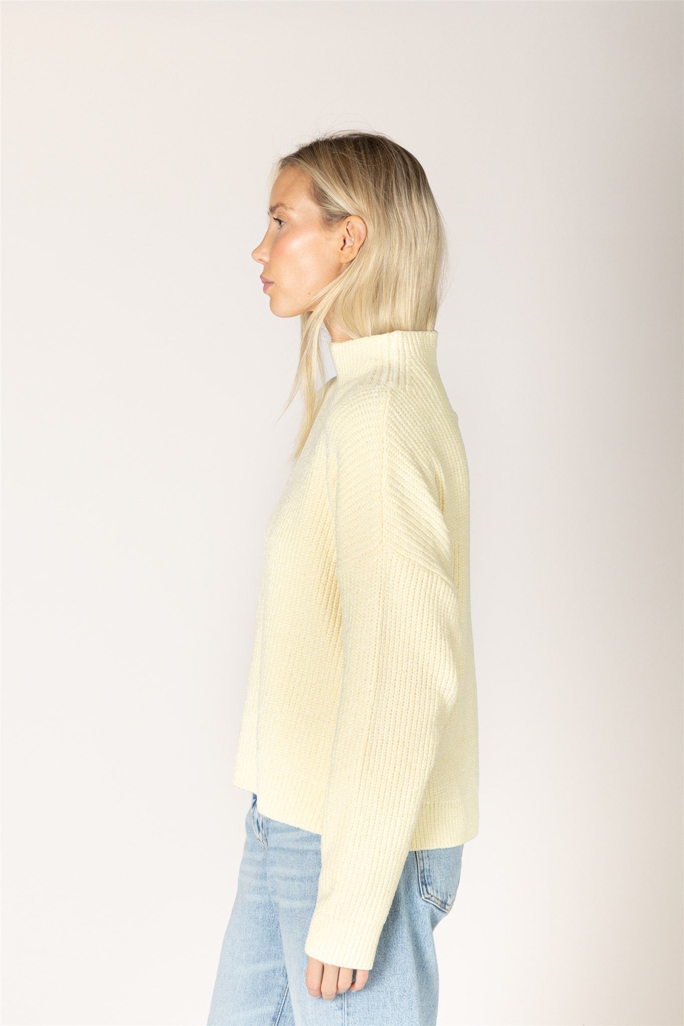 pale yellow ribbed knit sweater featuring a mock neckline, relaxed fit, and long sleeves.