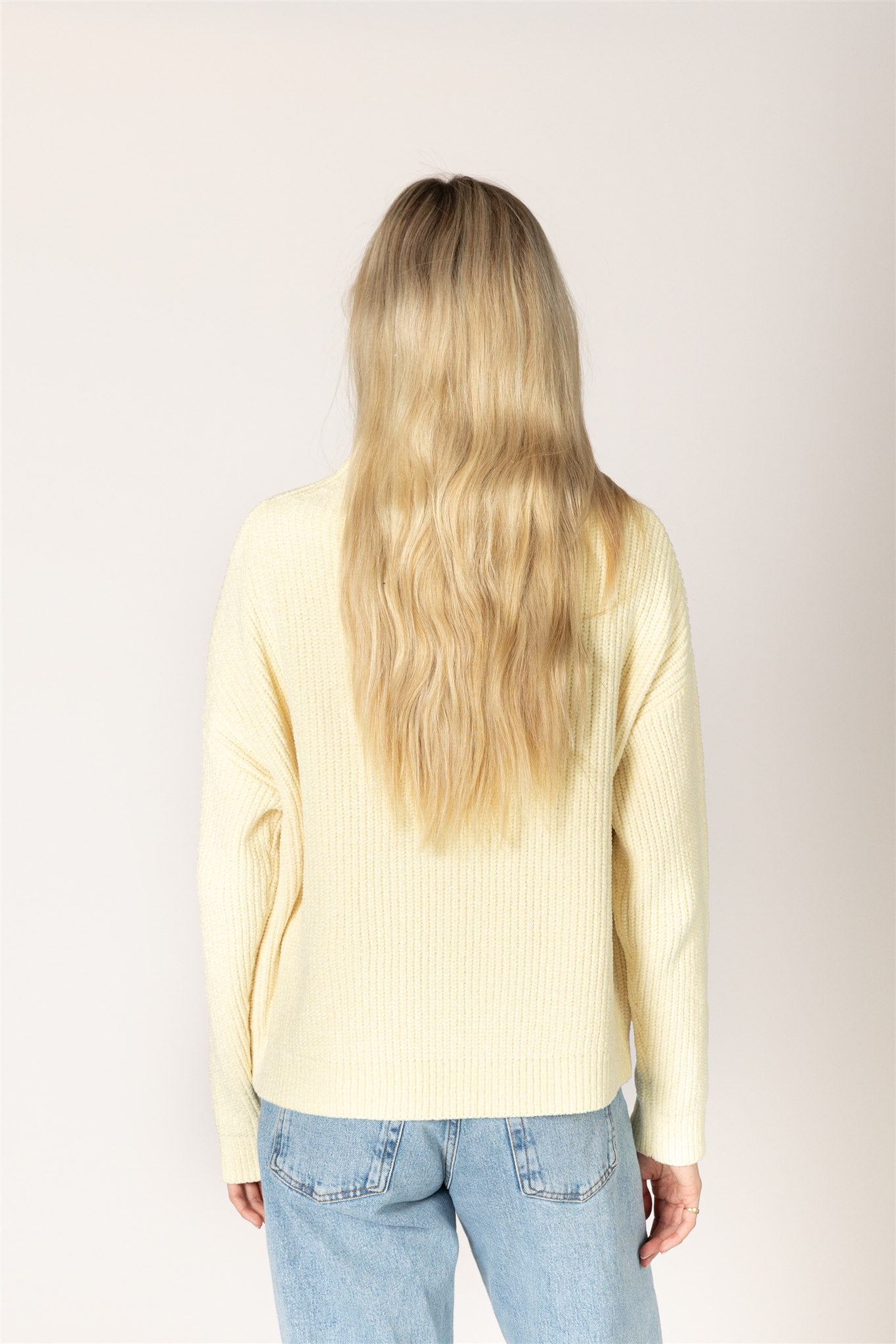 pale yellow ribbed knit sweater featuring a mock neckline, relaxed fit, and long sleeves.