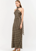 Make an unforgettable entrance in this stunning halter-neck midi dress. Showcasing a chic, classic polka dot motif against a rich, dark background, this piece features a sophisticated high neckline with a twisted halter strap detail that frames the shoulders to perfection. Cut in a sleek, fluid silhouette that gracefully skims the body, it offers an effortless blend of retro charm and contemporary style.&nbsp;