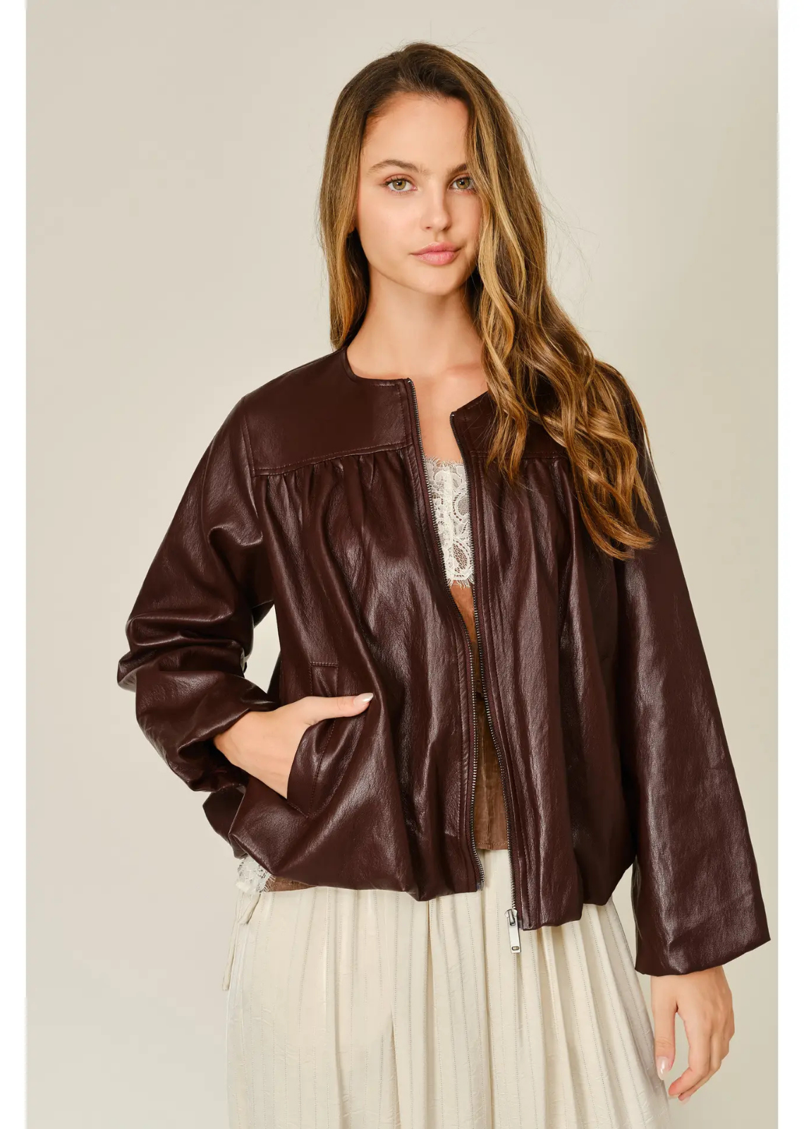 Merlot relaxed balloon bomber jacket in mahogany vegan leather, featuring a round neckline, front zip closure, pleated detailing, and elasticized cuffs and hem.