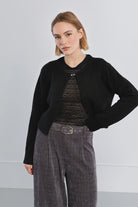 Fluffy knit open cardigan featuring a round neckline, long sleeves, and rhinestone button closure at the upper front.
