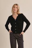 Short knit cardigan featuring long sleeves, a delicate lace-trimmed V-neckline, and classic full-length button-front closure.