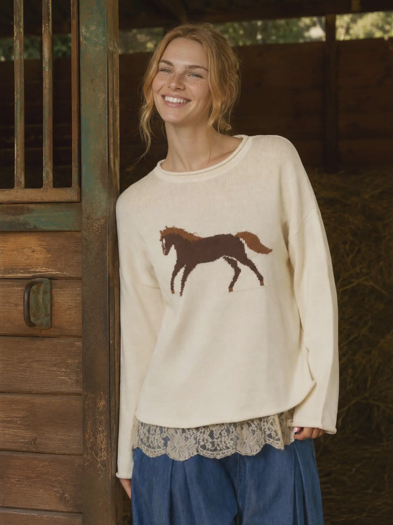 Women’s cream horse knit pullover featuring a relaxed fit, long sleeves, dropped shoulders, and western-inspired horse graphic. Lace under shirt shown is not included.