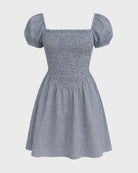 Blue checkered dress with puff sleeves on a light gray background