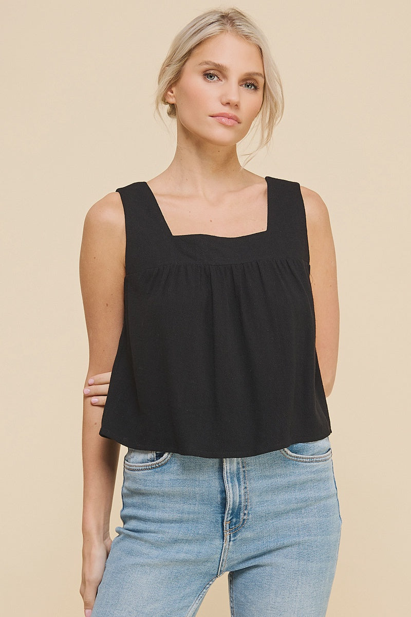 woman wearing a black linen and cotton blend tank with thick straps and a flowy fit