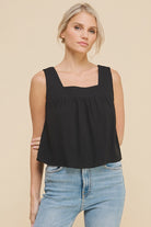 woman wearing a black linen and cotton blend tank with thick straps and a flowy fit