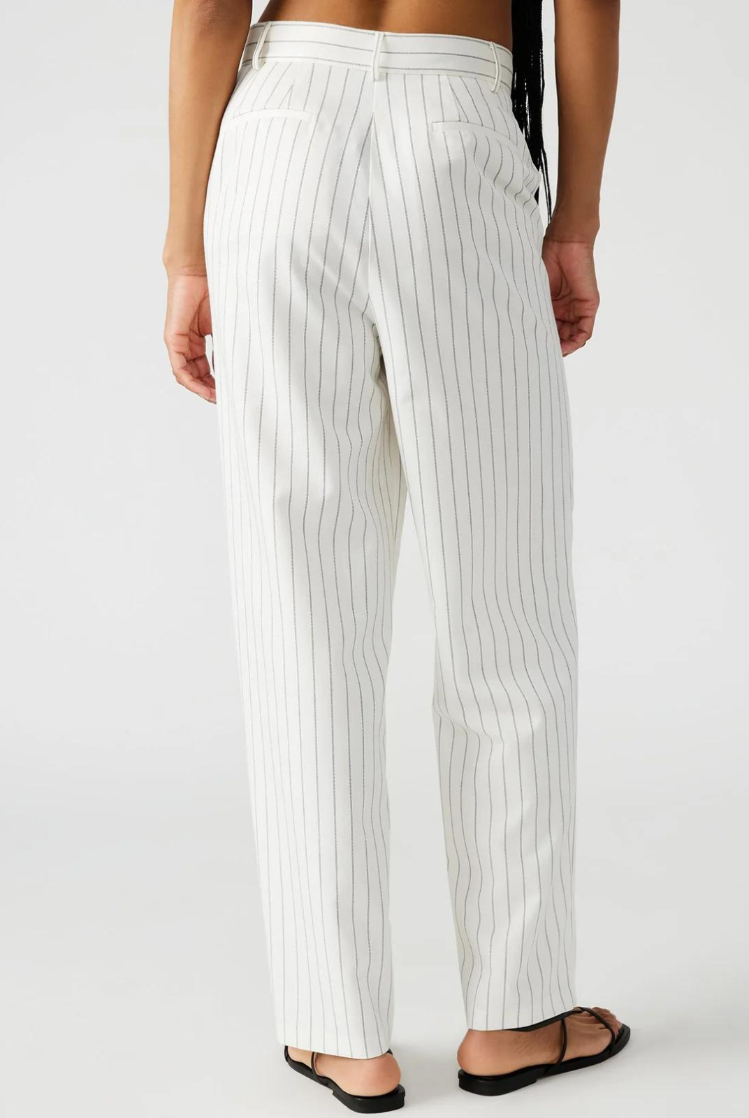 Steve Madden Rumi Pant.Elevate your spring wardrobe with the Rumi pant. These pinstripe suiting trousers are menswear inspired and feature a tapered design and pleated detailing. These trousers offer a sophisticated and polished look for any occasion.