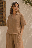Women's brown linen blend camp shirt with a relaxed boxy fit, button-front closure, camp collar, oversized patch pockets, and contrast stitching.