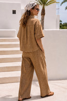 Women's brown linen blend wide leg pants with a relaxed fit, elastic waistband, side pockets, and contrast stitching.