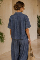 Women's denim blue linen blend camp shirt with a relaxed boxy fit, button-front closure, camp collar, oversized patch pockets, and contrast stitching.