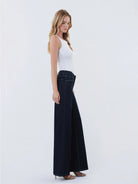 Dark wash wide-leg jeans featuring a mid-rise waist, trouser-inspired front crease, classic five-pocket design, finished hem, and full-length silhouette.