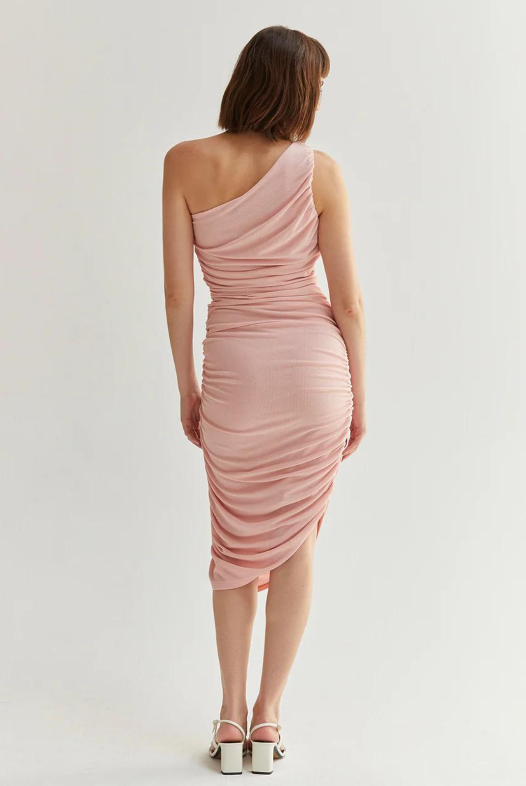 Vienna Knit Dress.The Vienna Knit Dress features a one shoulder construction, ruching detail on both sides, asymmetric hemline, and invisible zipper on the side. Designed for a midi length with fit to bodice silhouette.