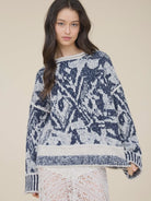 Women’s navy and cream printed knit pullover featuring an all-over pattern, relaxed fit, long sleeves, and contrast ribbed trim.