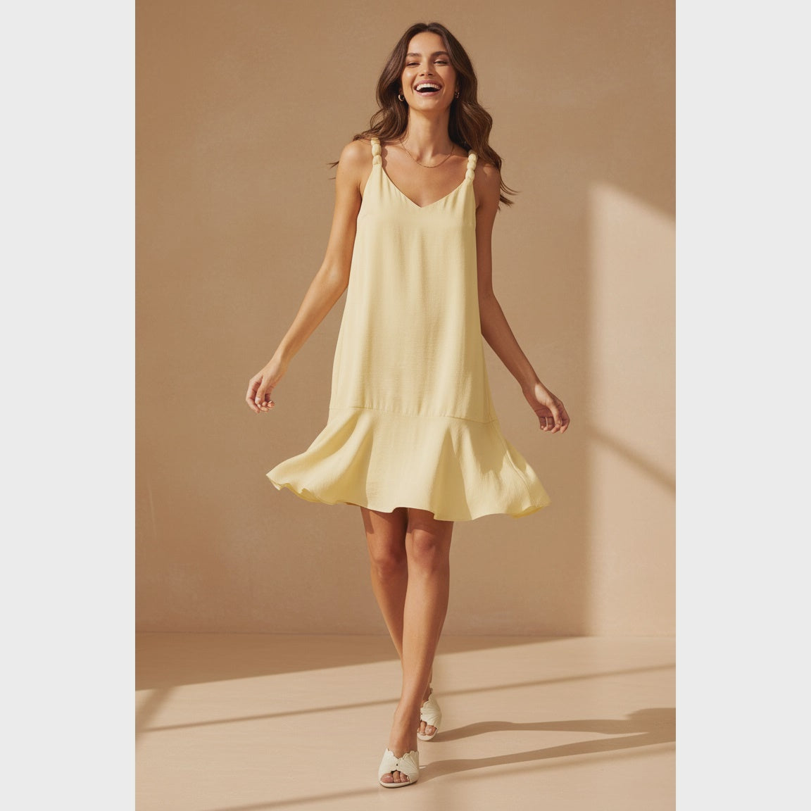 Pale banana sleeveless mini dress featuring a V-neckline, delicate ball-detail shoulder straps, a relaxed A-line silhouette, and a flutter hem